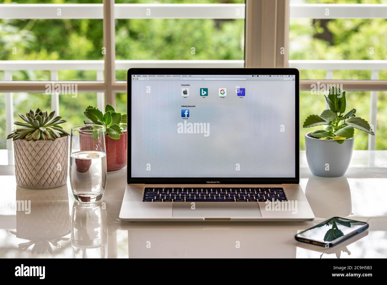 Home office with laptop, Apple MacBook Pro with iPhone X at your desk, with browser Safari, Germany Stock Photo