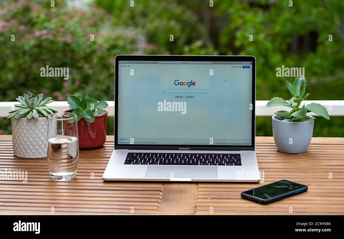 Home office with laptop, Apple MacBook Pro with iPhone X at the desk, with website Google, Germany Stock Photo