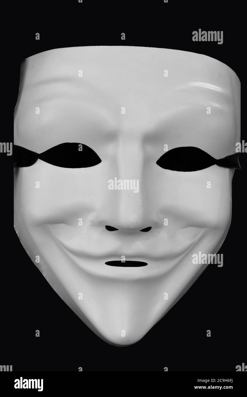 Anonymous white mask isolated on a black background Stock Photo - Alamy