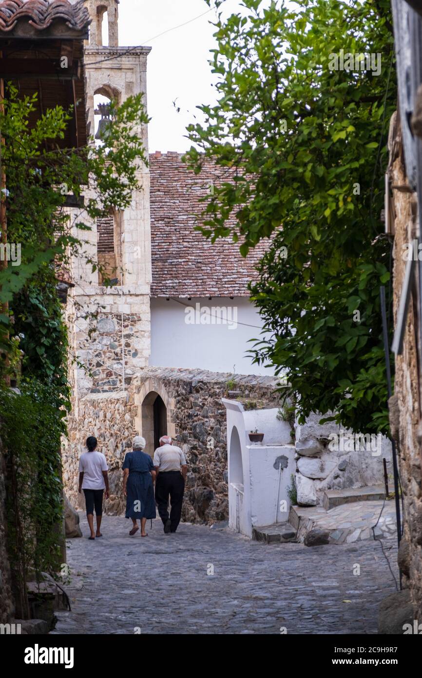 People strolling in the picturesque narrow streets of old Kakopetria in the Troodos mountains in Cyprus with a girl walking in the distance Stock Photo