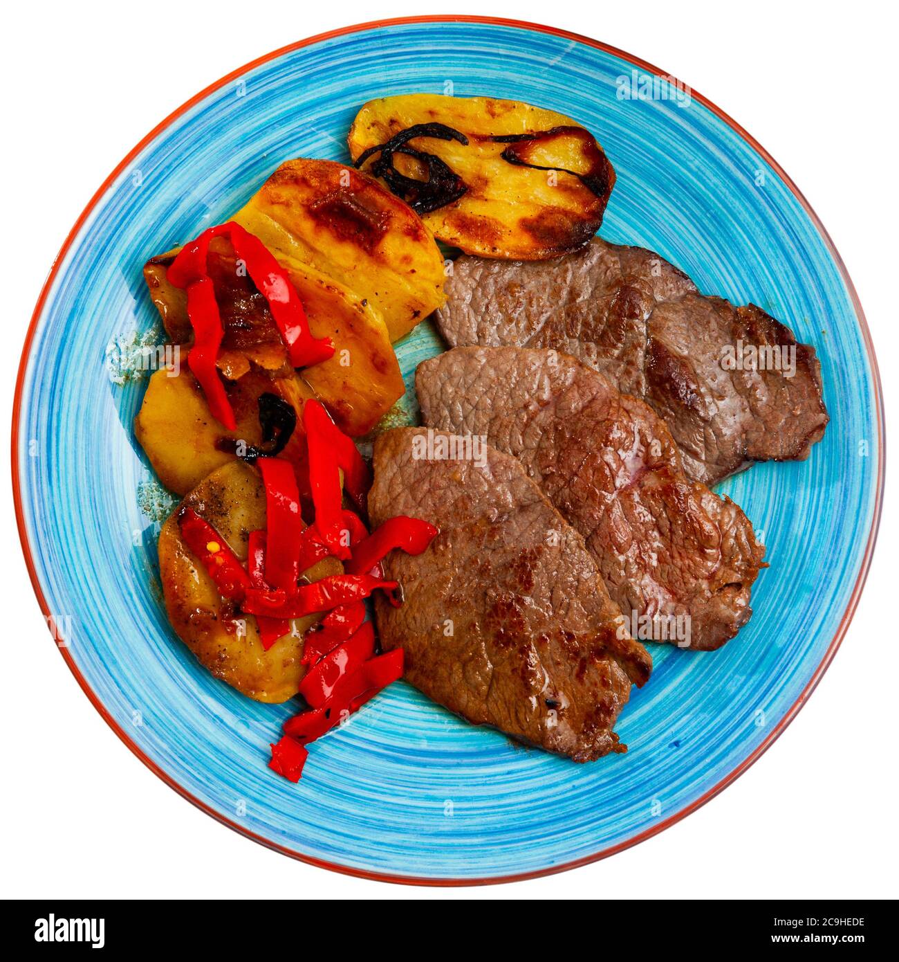 Medium rare beef steaks with vegetable side dish of baked potatoes and ...