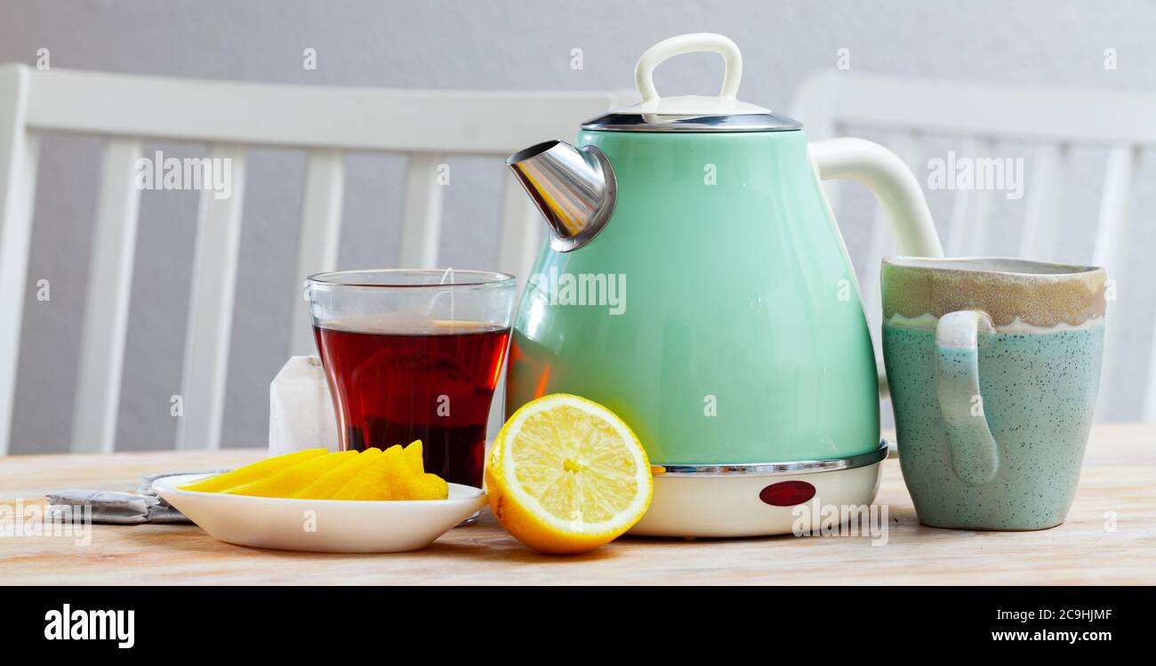https://c8.alamy.com/comp/2C9HJMF/new-teapot-on-table-with-cup-of-black-tea-and-sliced-lemon-in-home-interior-nobody-2C9HJMF.jpg