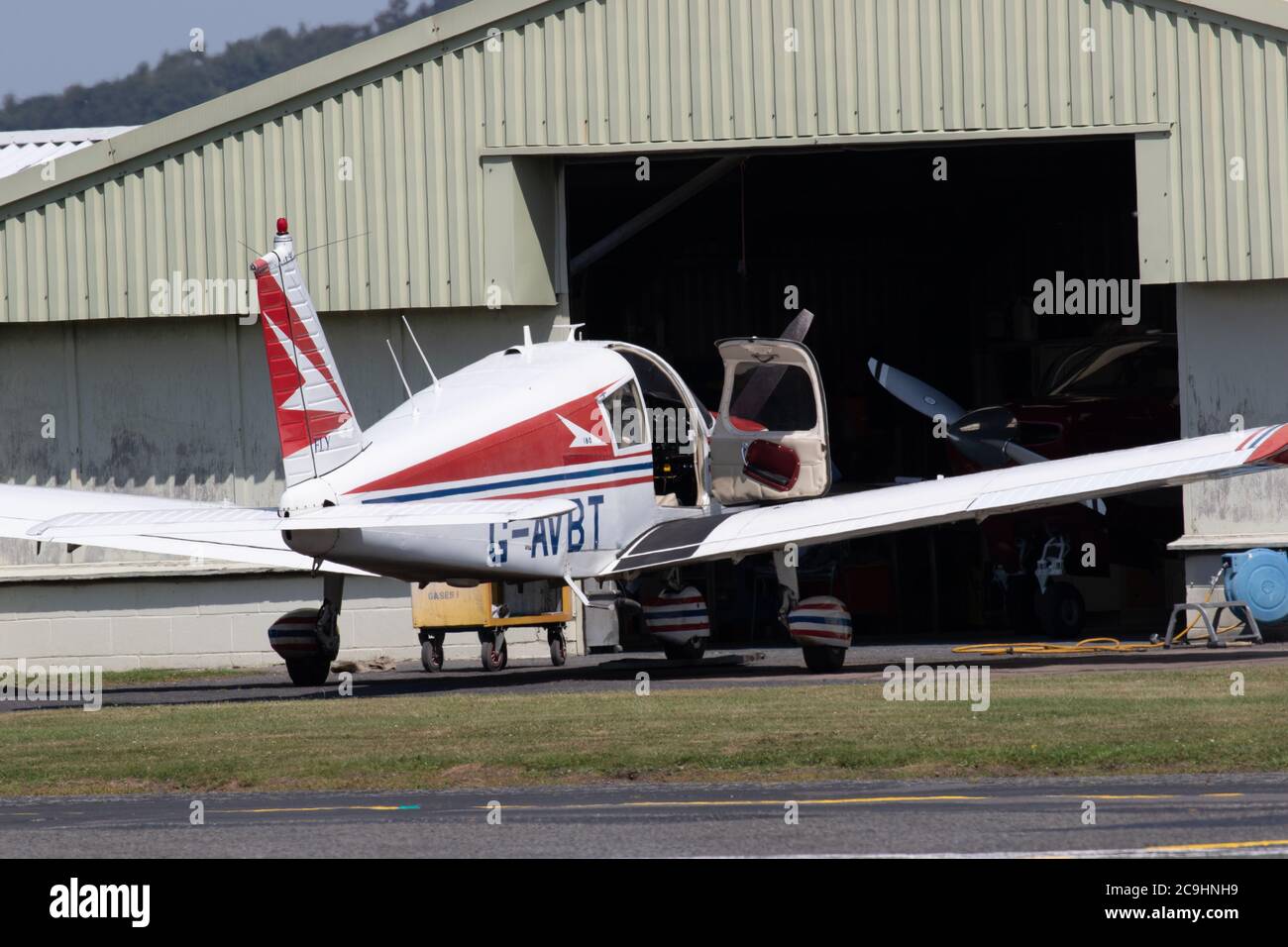 Light aircraft parked outside of hanger. Wolverhampton Halfpenny Green Airport. Bobbington. Staffordshire. UK Stock Photo