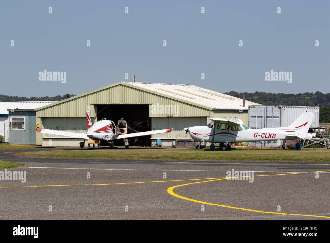 Light aircraft parked outside of hanger. Wolverhampton Halfpenny Green Airport. Bobbington. Staffordshire. UK Stock Photo