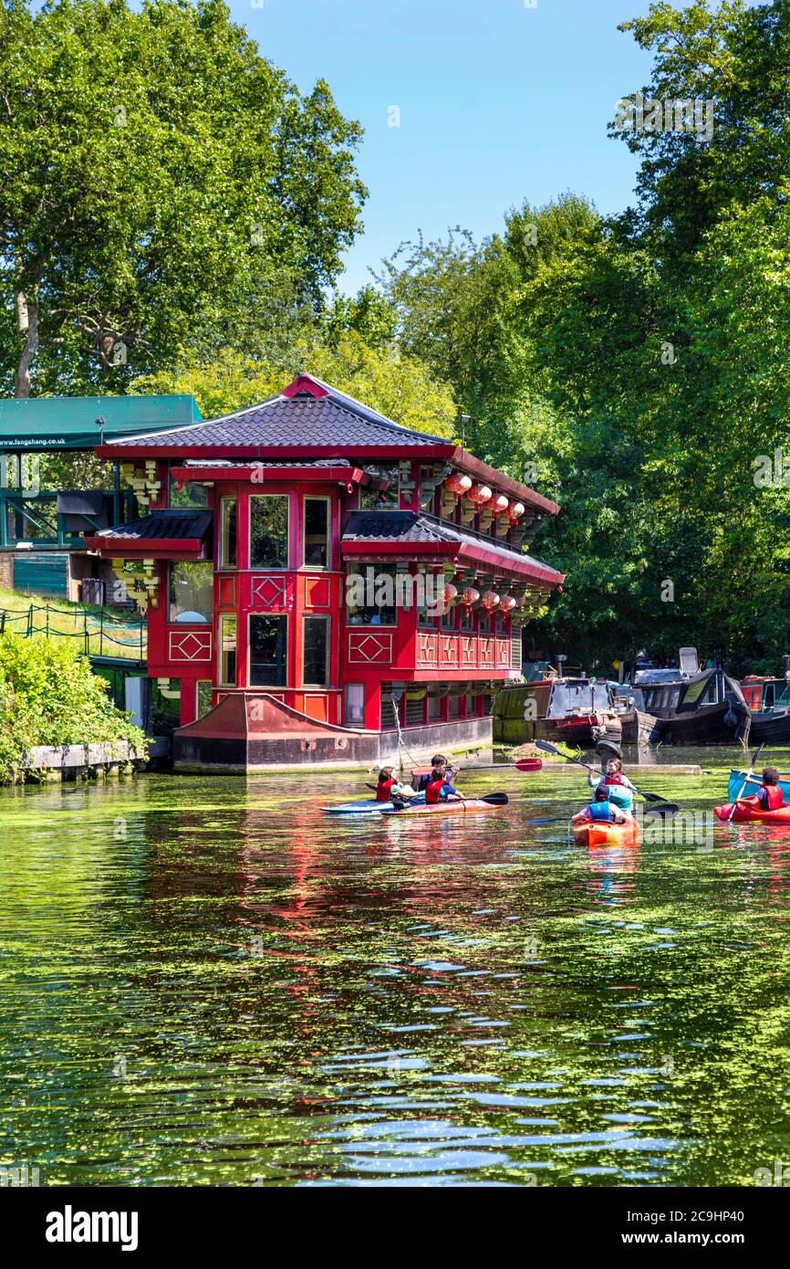 Floating Chinese restaurant Feng Shang Princess on Regent's Canal and people kayaking, Primrose Hill, London, UK Stock Photo