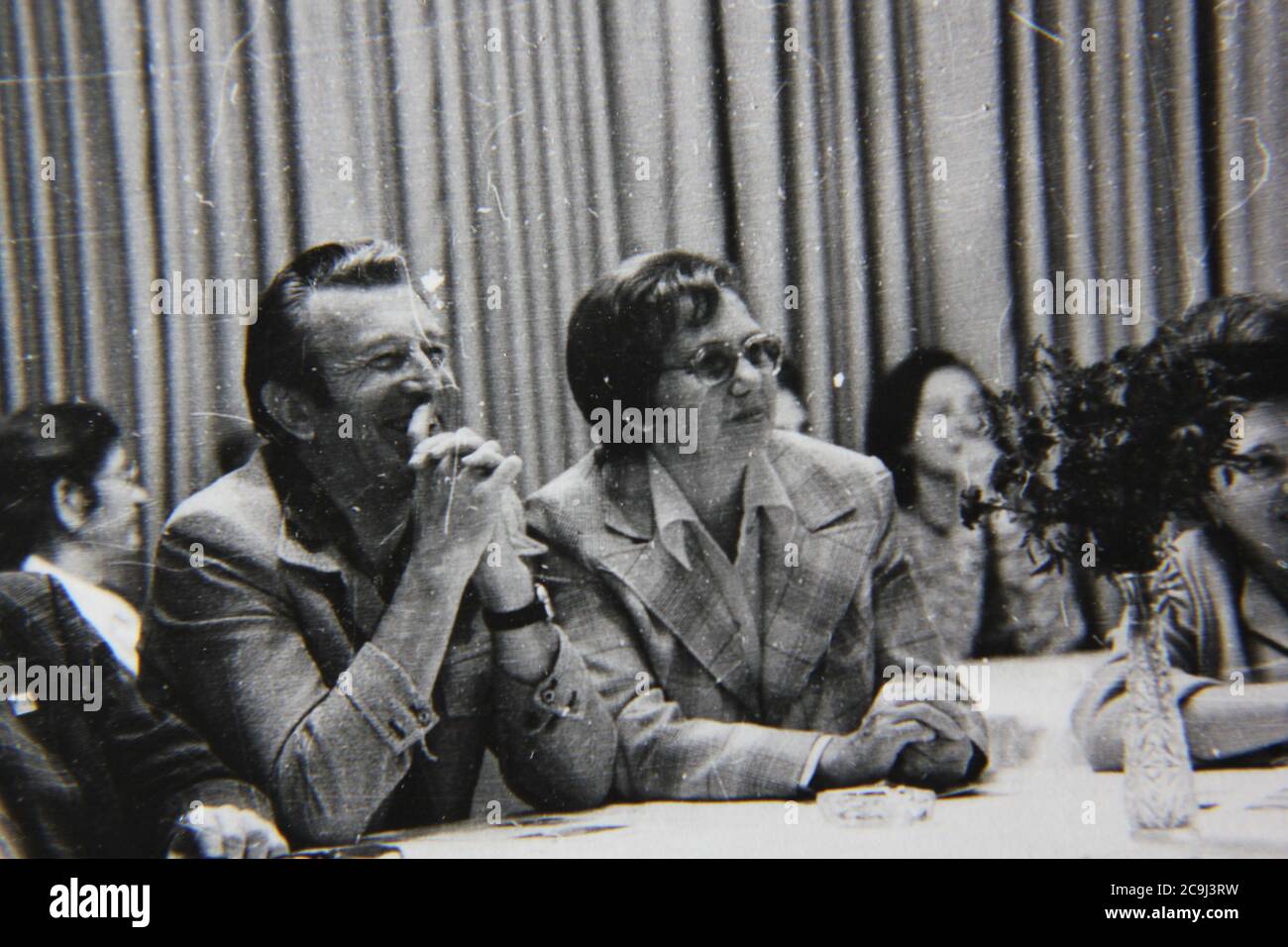 Fine 1970s vintage black and white photography of regular people mingling at a formal dinner party. Stock Photo