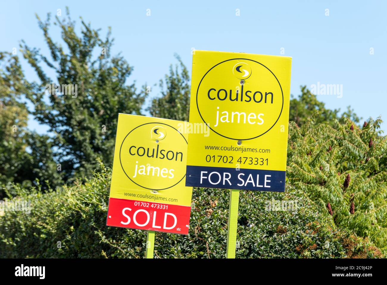 Coulson James estate agents for sale, and sold property boards. Trees. Property market in exclusive Leigh on Sea area with leafy background Stock Photo