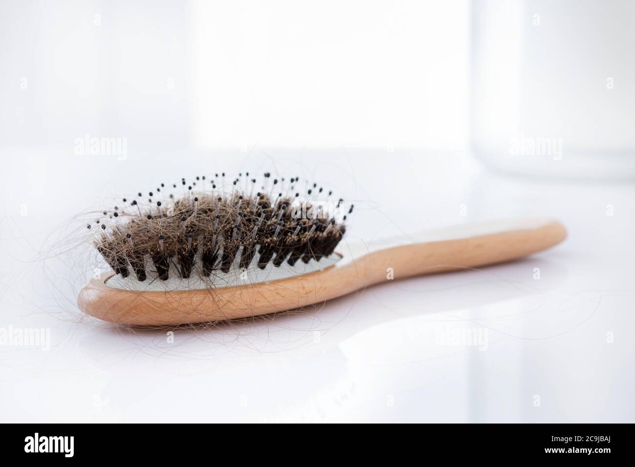 Hairbrush covered with hair, studio shot. Stock Photo