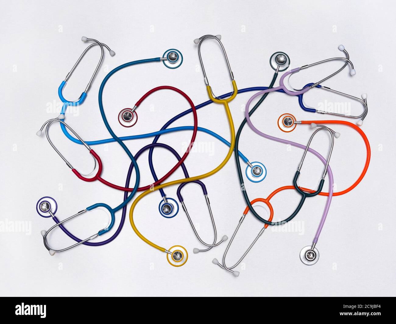 Multicoloured stethoscopes against a white background. Stock Photo