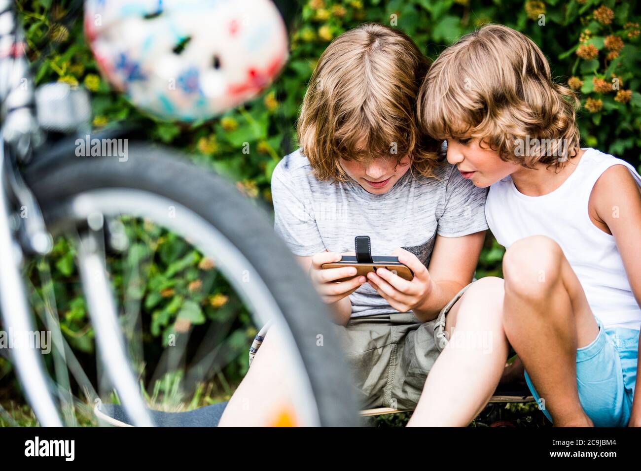Boys playing games on mobile phone. Stock Photo