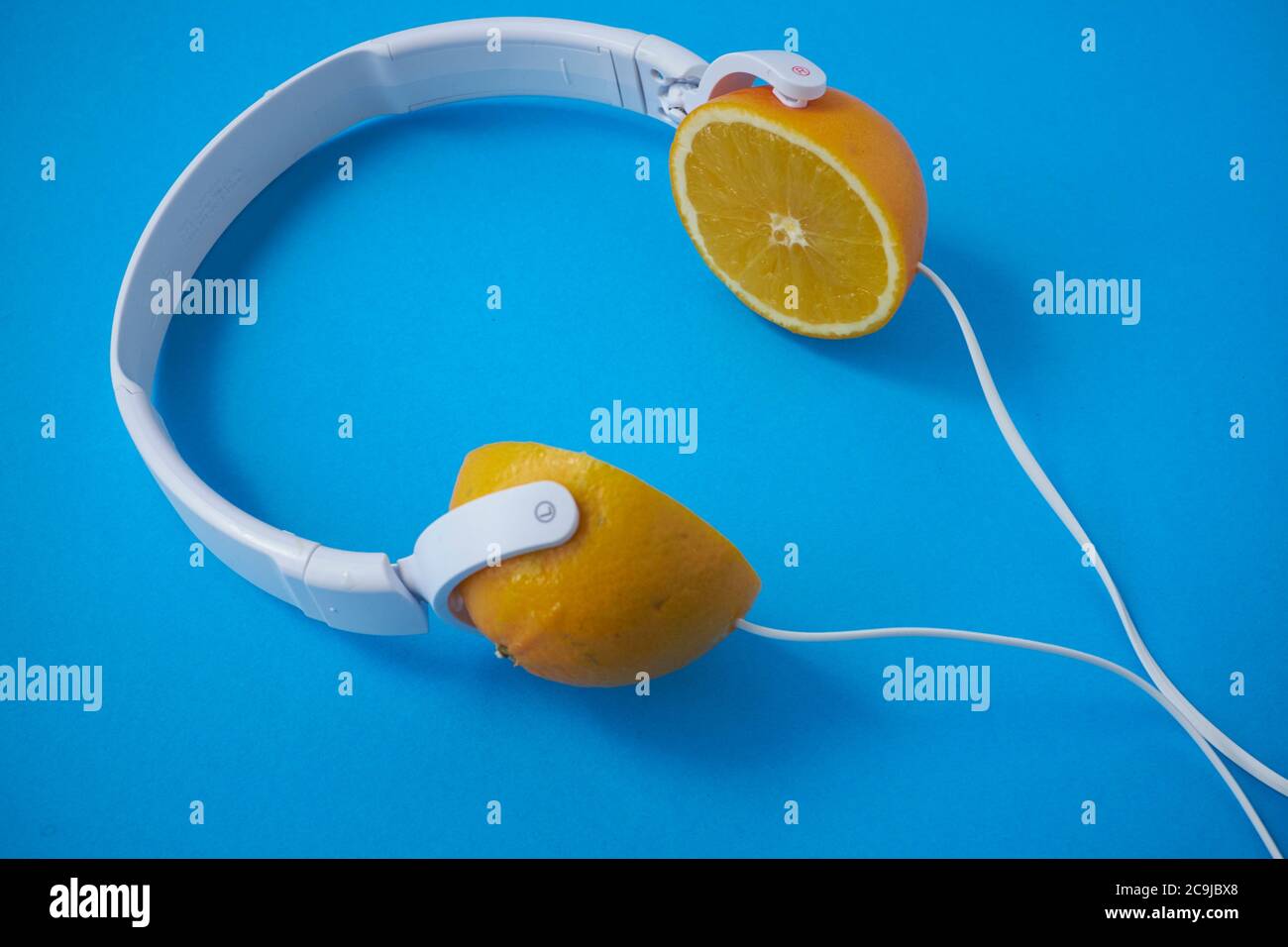 Headphones with lemons against a blue background. Stock Photo