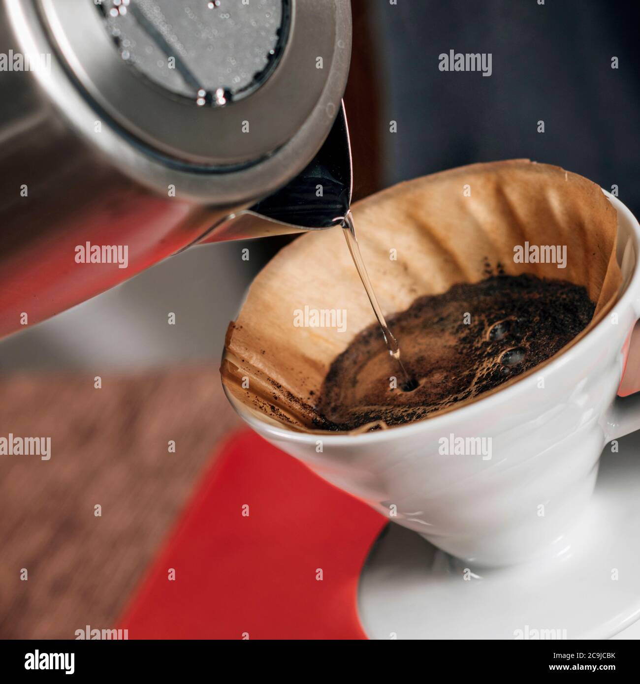 Filter coffee. Pouring boiling water from kettle into manual coffee