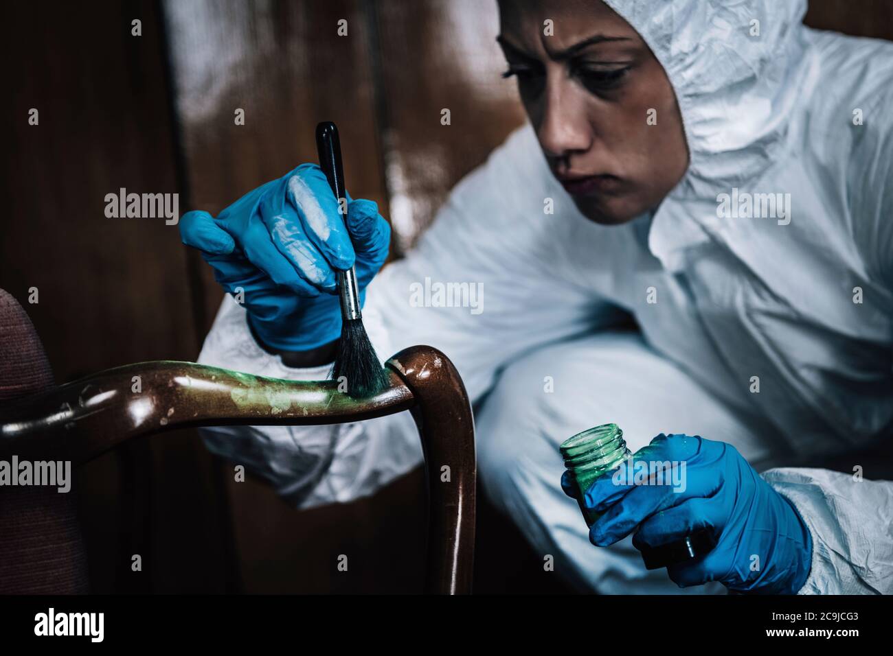 Crime scene. Forensics expert dusting for fingerprints at a crime scene