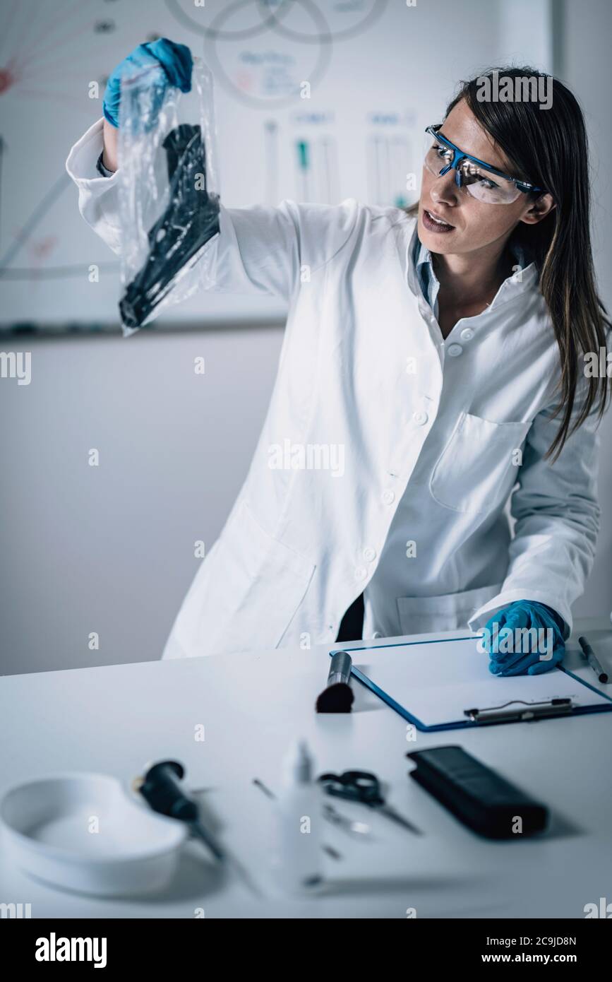 Forensic Science in Lab. Forensic Scientist examining gun for evidence