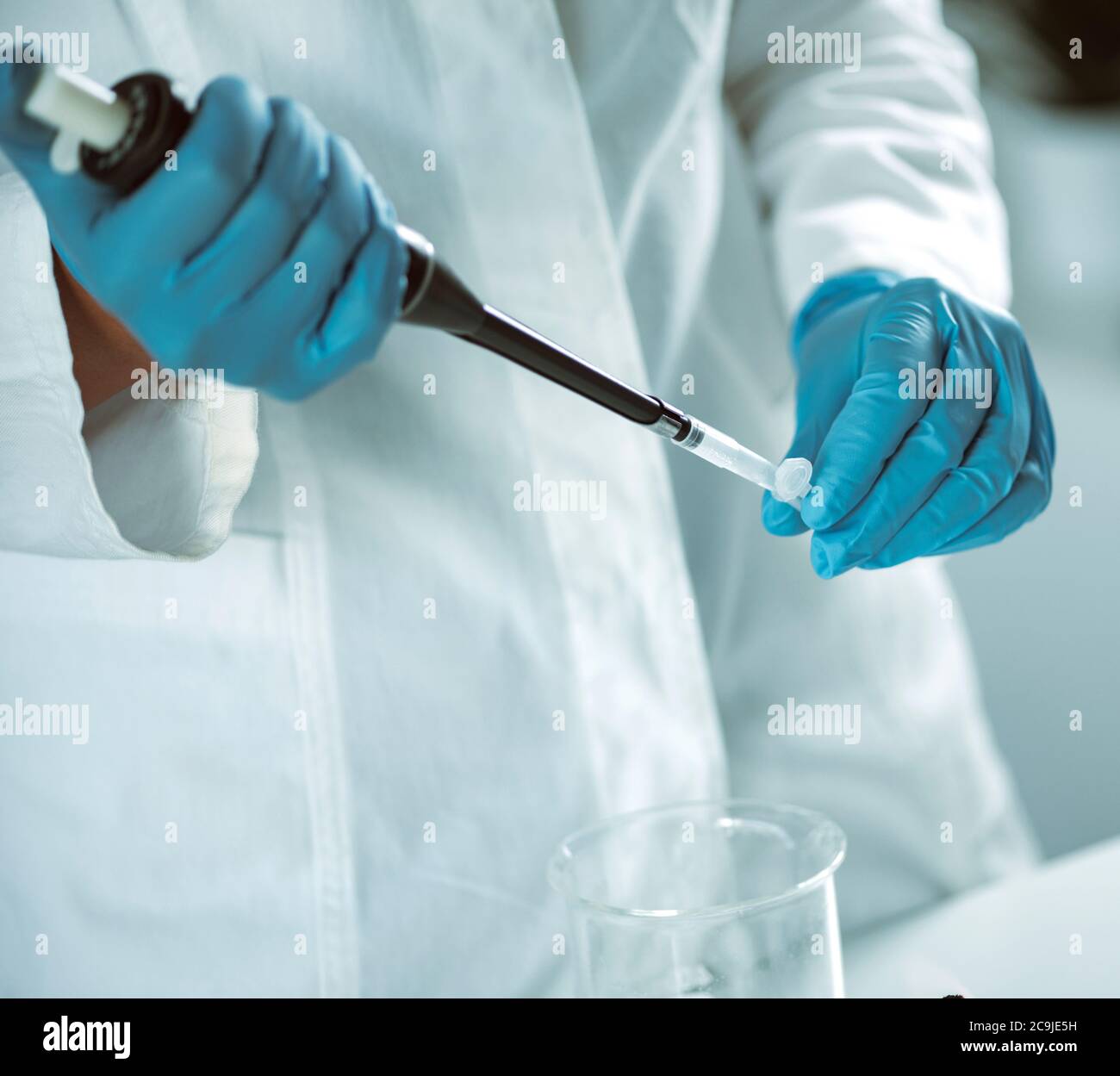 Microbiology. Hands of a microbiologist pipetting sample Stock Photo