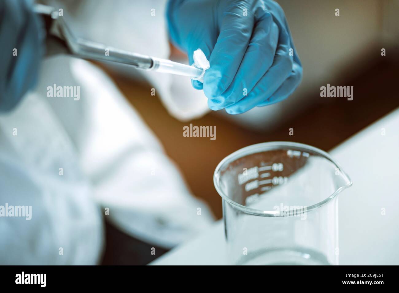 Microbiology. Hands of a microbiologist pipetting sample Stock Photo