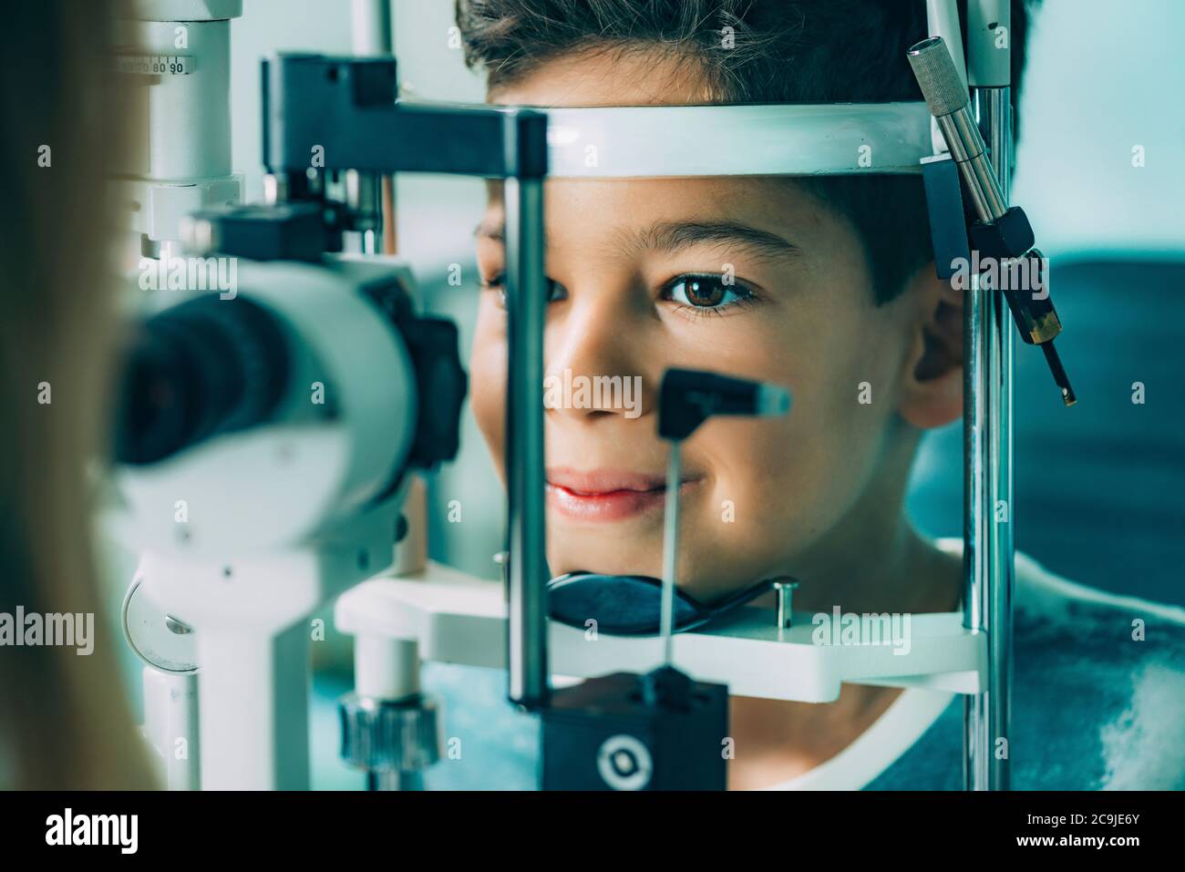 Ophthalmologist examining boy's eyes with a slit lamp . Stock Photo