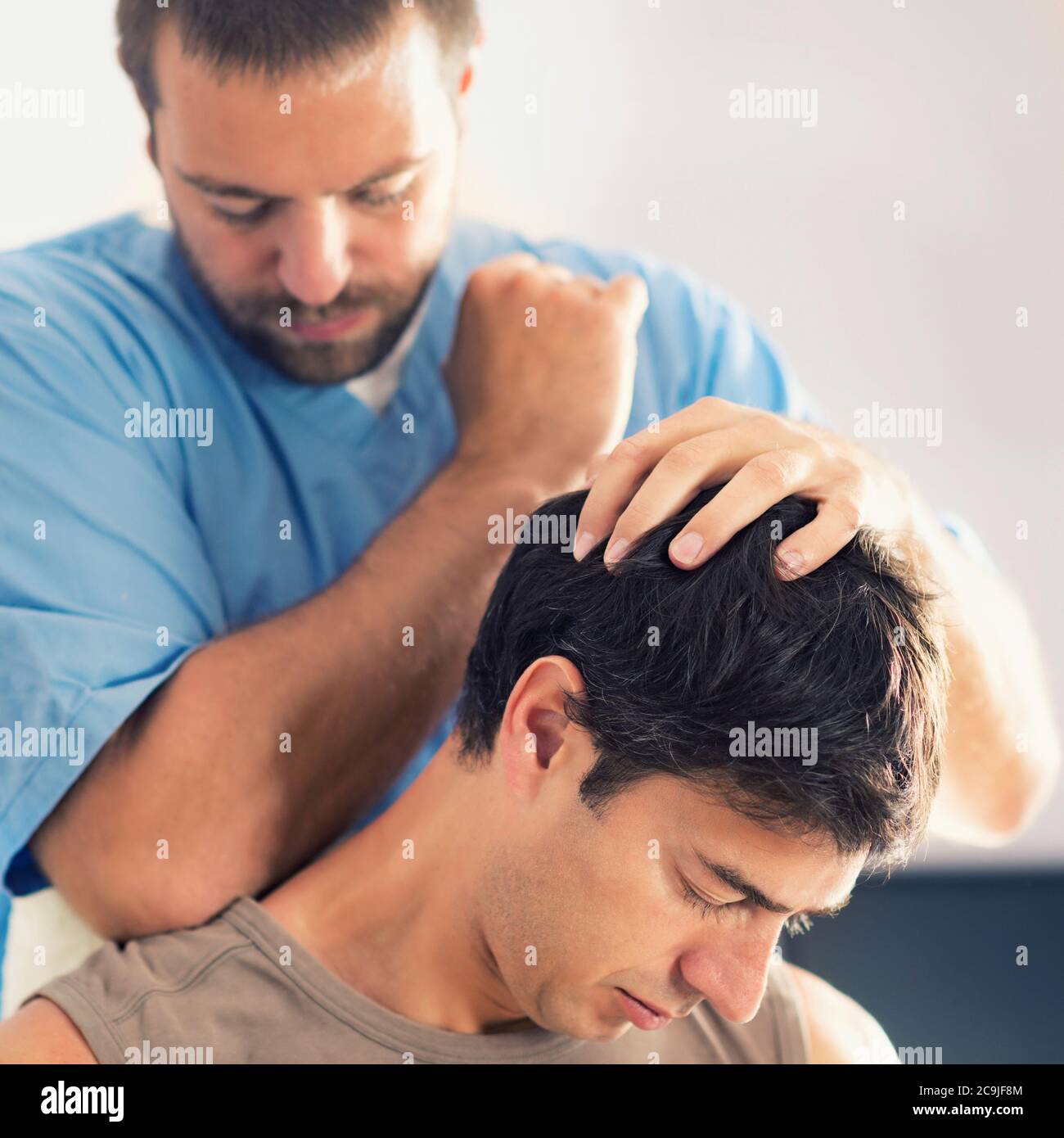Physiotherapist massaging man's shoulders. Stock Photo