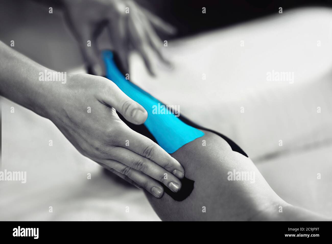 Physical therapist placing kinesio tape on patient's Achilles tendon