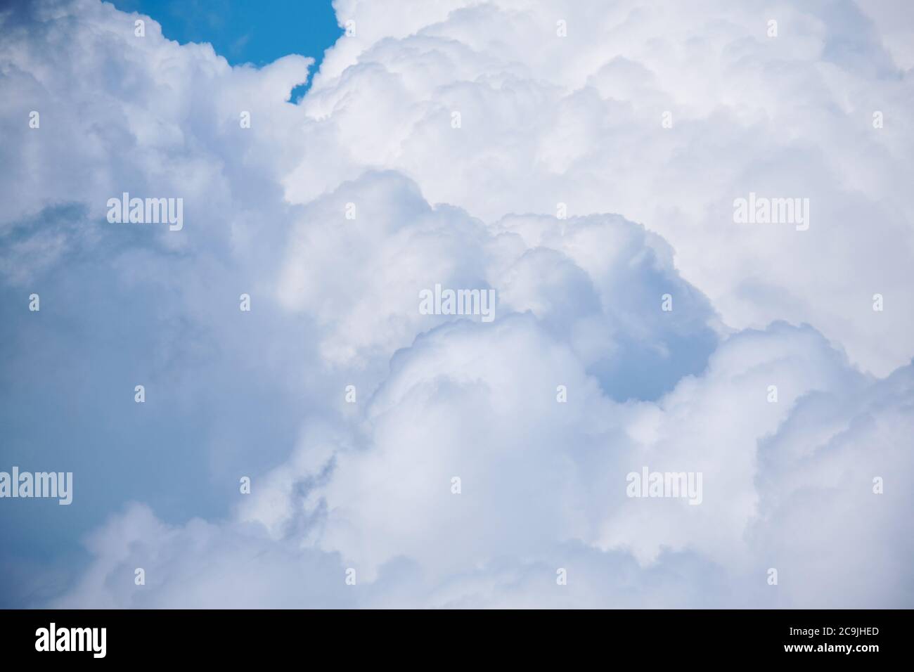 Large white clouds with thunderstorms in the blue sky. Stock Photo