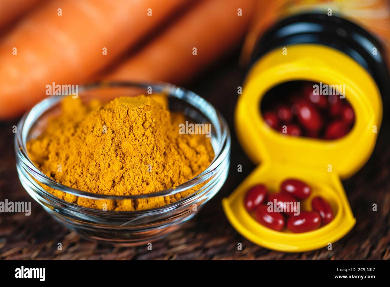 Beta carotene supplements pills and natural sources of beta carotene in fresh vegetables. Antioxidant supplements and natural sources of beta carotene Stock Photo