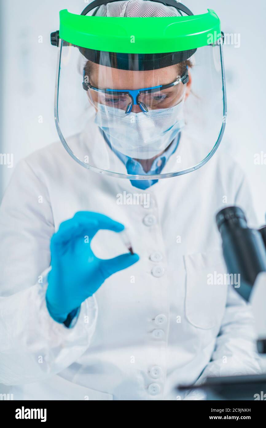 Ancient DNA analysis. Female scientist holding micro tube with sample