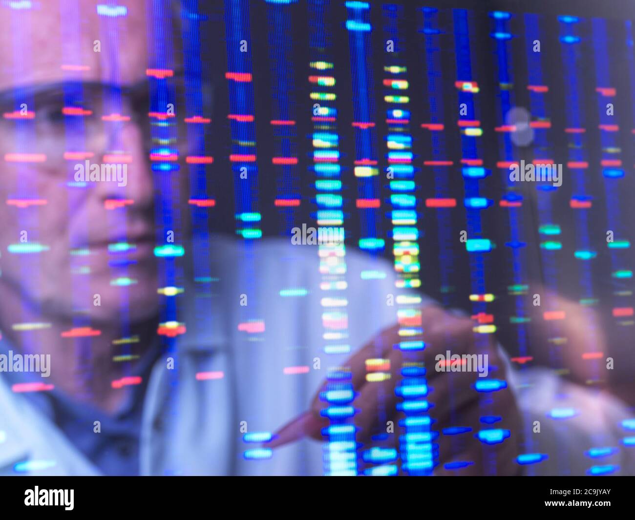 Scientist viewing DNA (deoxyribonucleic acid) profiles on a computer screen. Stock Photo