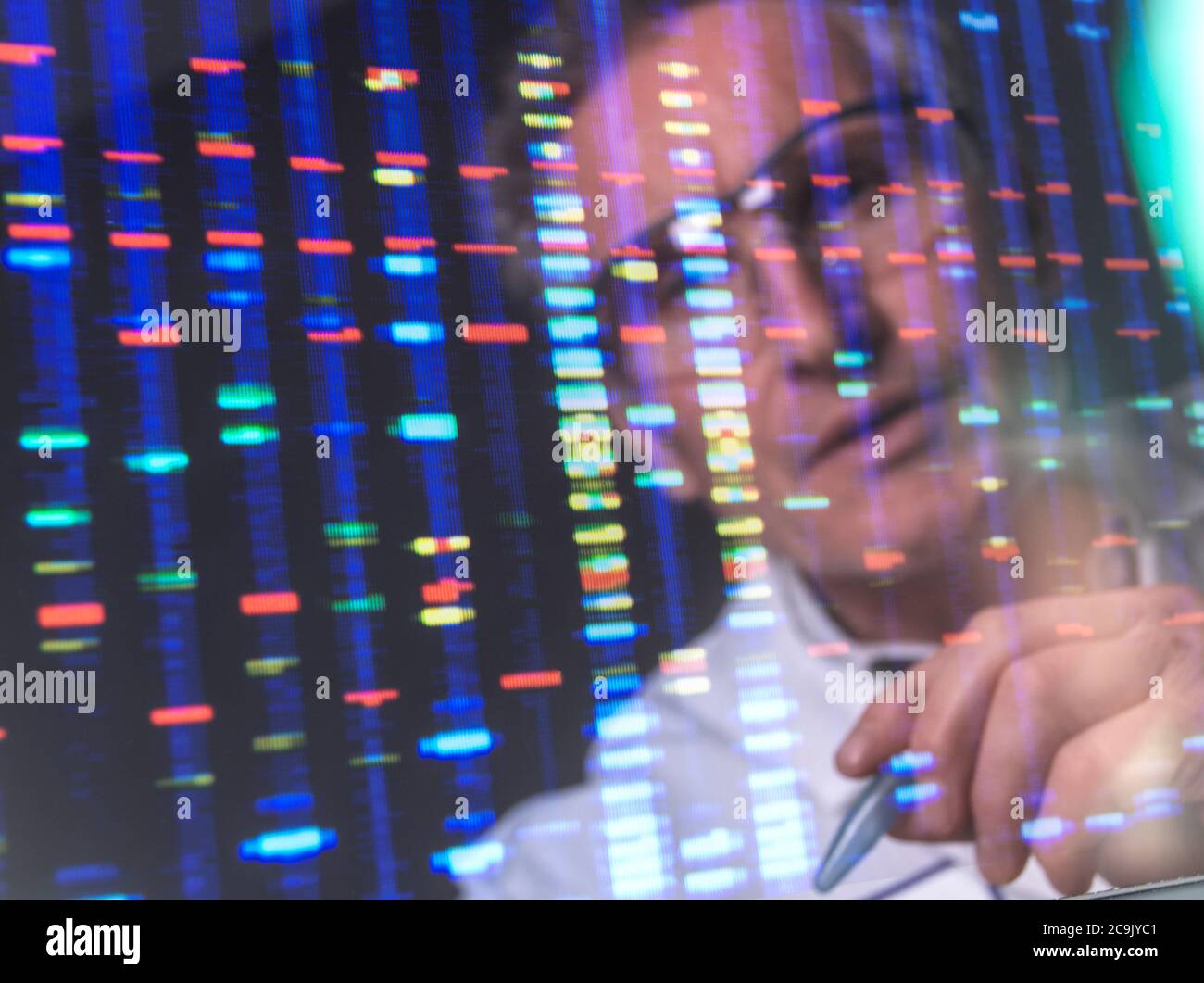Scientist viewing DNA (deoxyribonucleic acid) profiles on a computer screen. Stock Photo