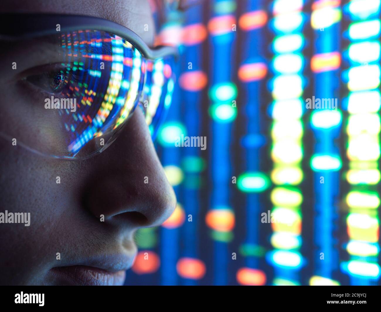 Scientist viewing DNA (deoxyribonucleic acid) profiles. Stock Photo