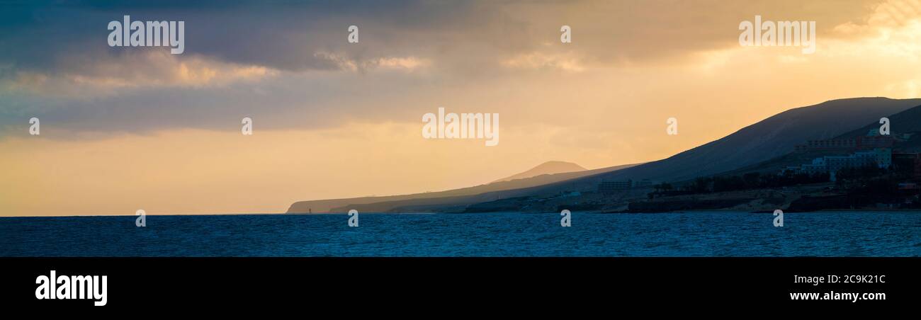Sun setting behind mountains. Stock Photo