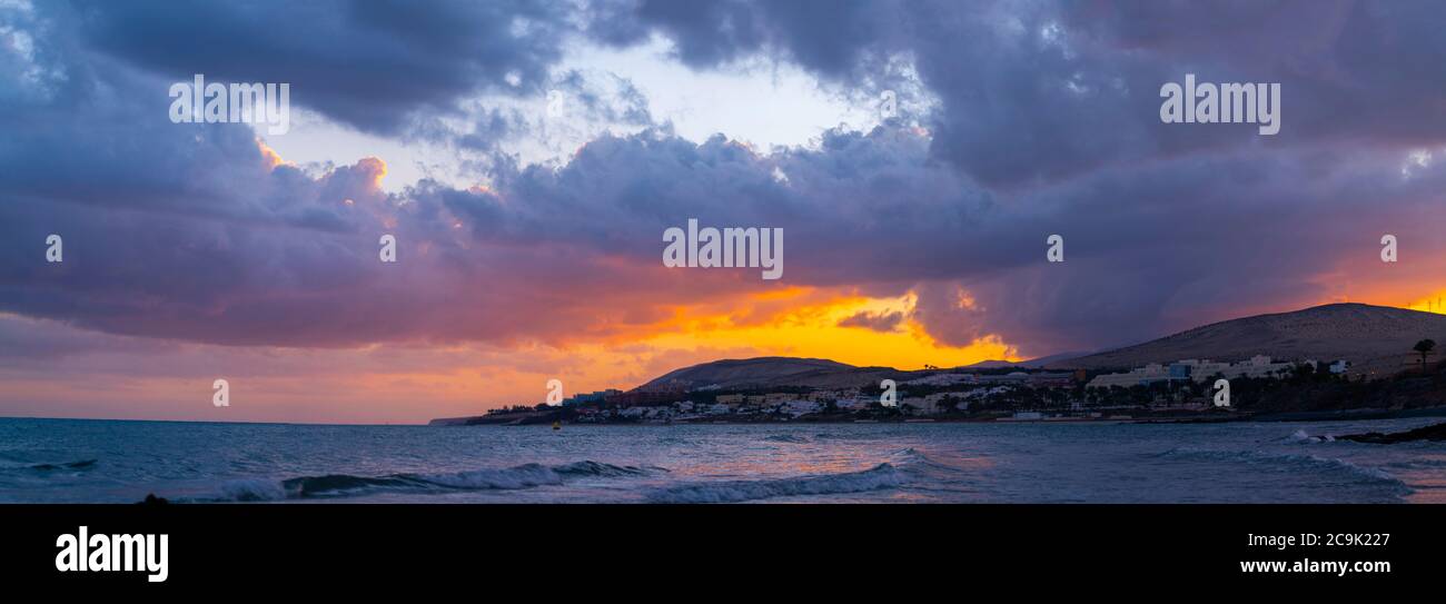 Sun setting behind mountains. Stock Photo