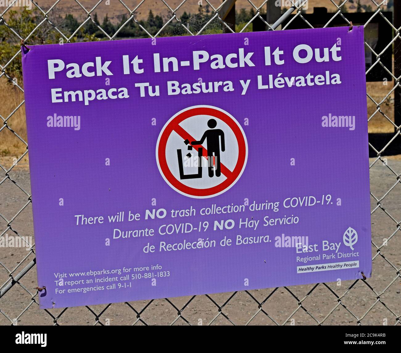 pack it in - pack it out, no trash collection during covid 19 sign in Spanish and English at Alameda Creek Regional Trail, Isherwood Staging Area in Fremont, California Stock Photo