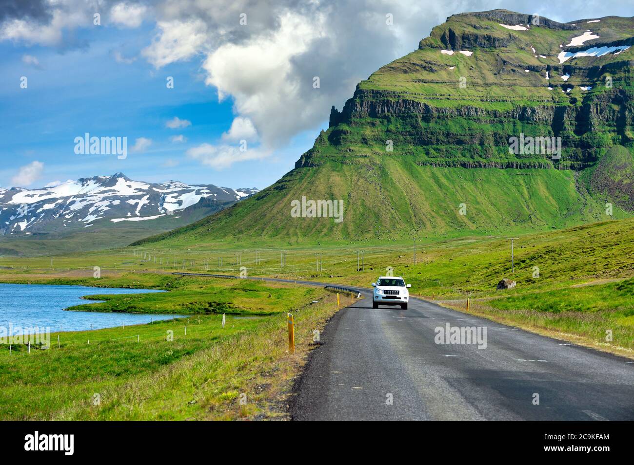 White cars running on a curved road The background is a great mountain