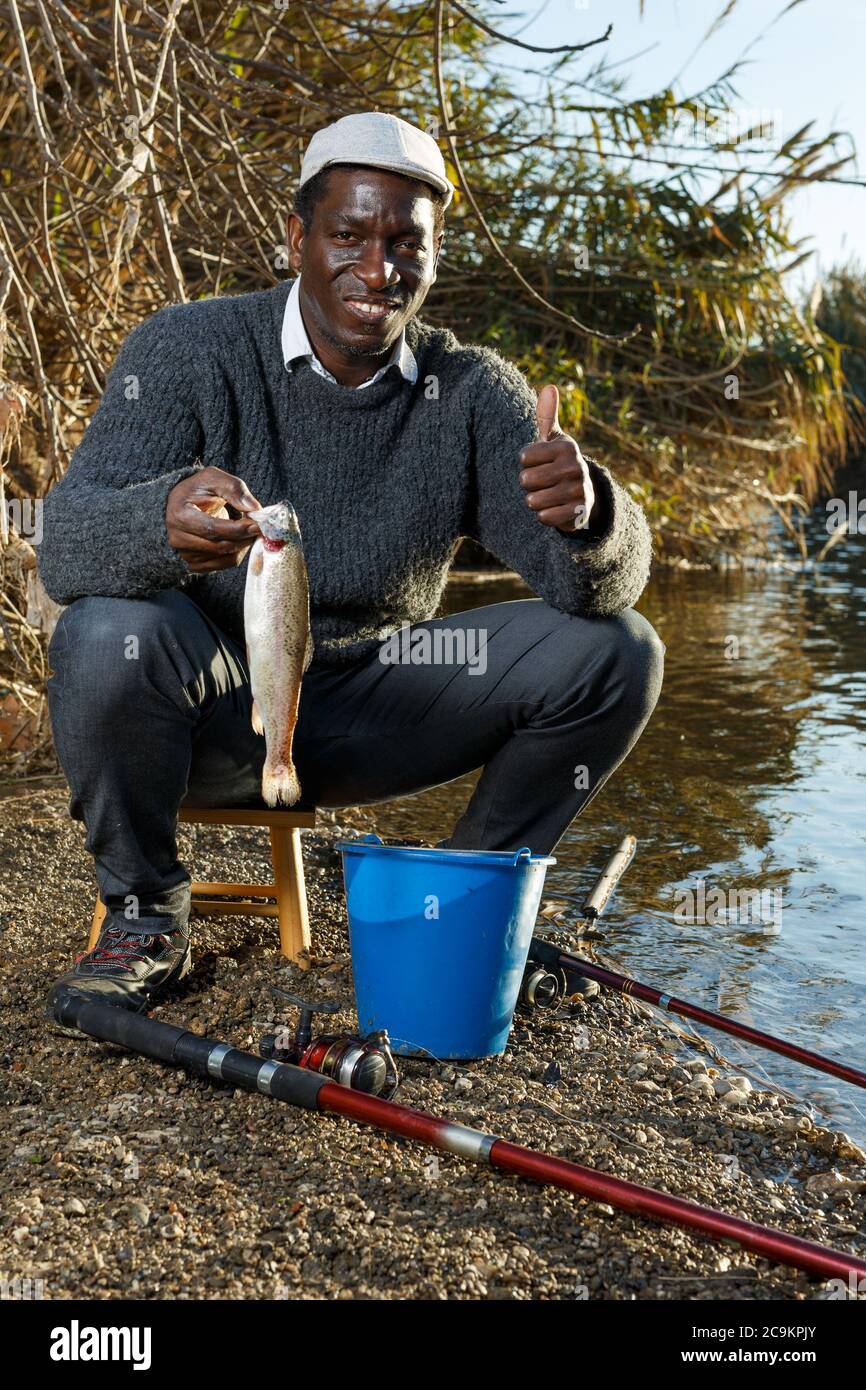 Portrait of African man fishing with rods on river and holding fish Stock  Photo - Alamy