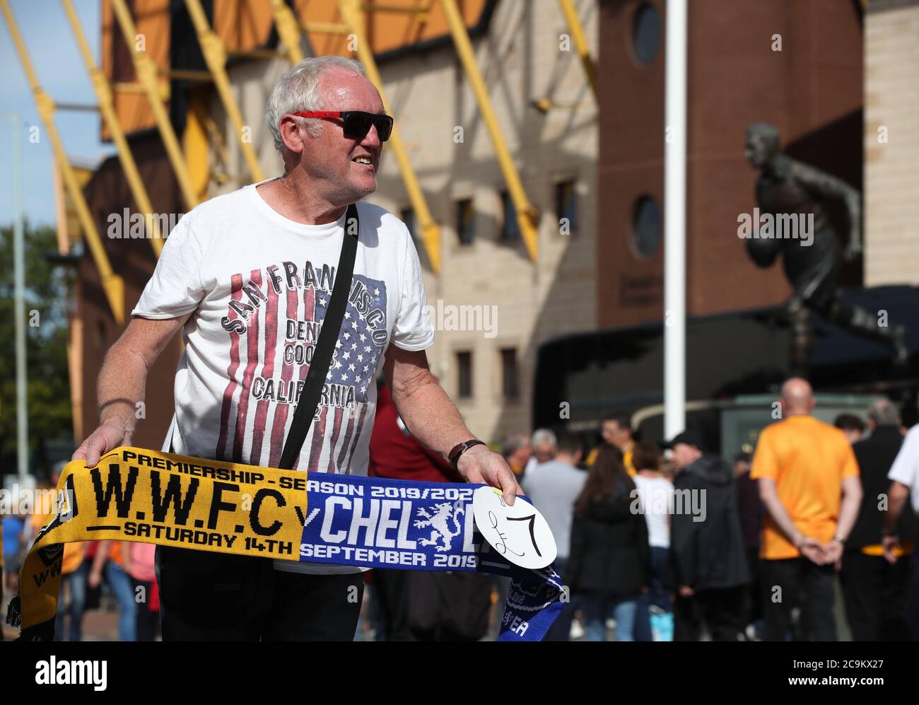 Street seller of Wolves and Chelsea half and half scarfs outside Molineux and near Billy Wright statue on Waterloo Street prior to the Premier League match at Molineux, Wolverhampton. Stock Photo