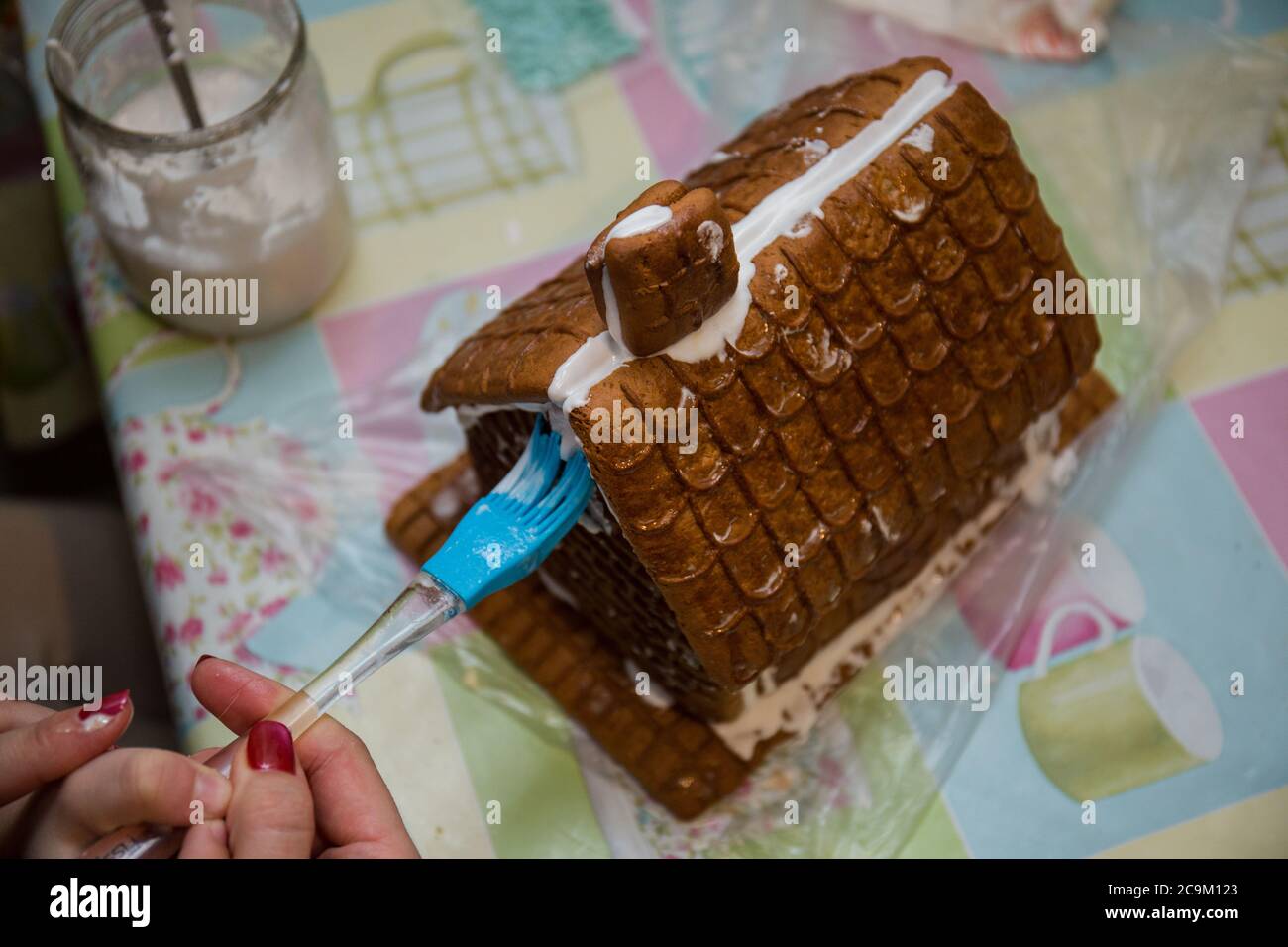 making a gingerbread house on kitchen table Stock Photo