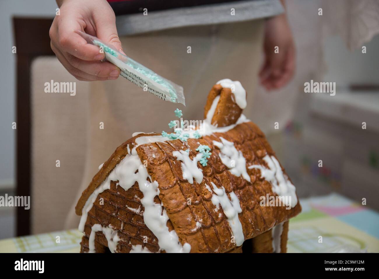 making a gingerbread house on kitchen table Stock Photo