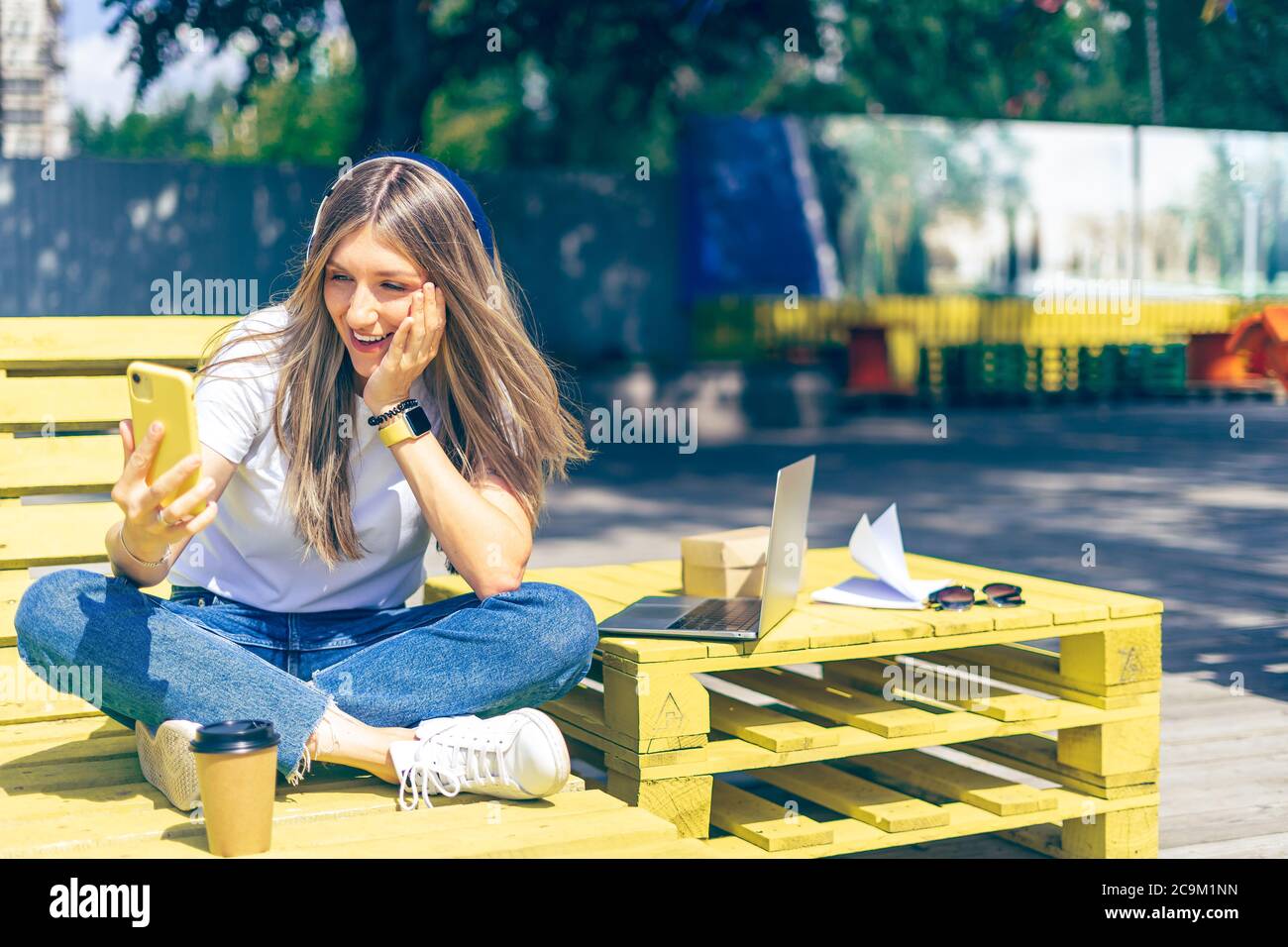 Woman in headphones having a video call with smartphone. Happy and ...