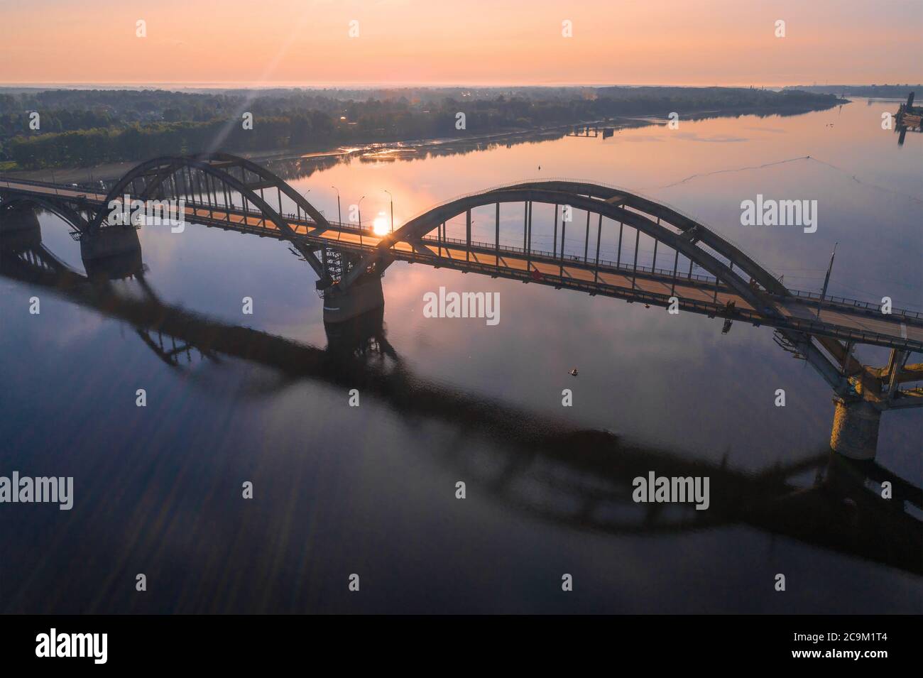 Over the automobile  bridge across the Volga river in the early July morning. Rybinsk, Russia Stock Photo