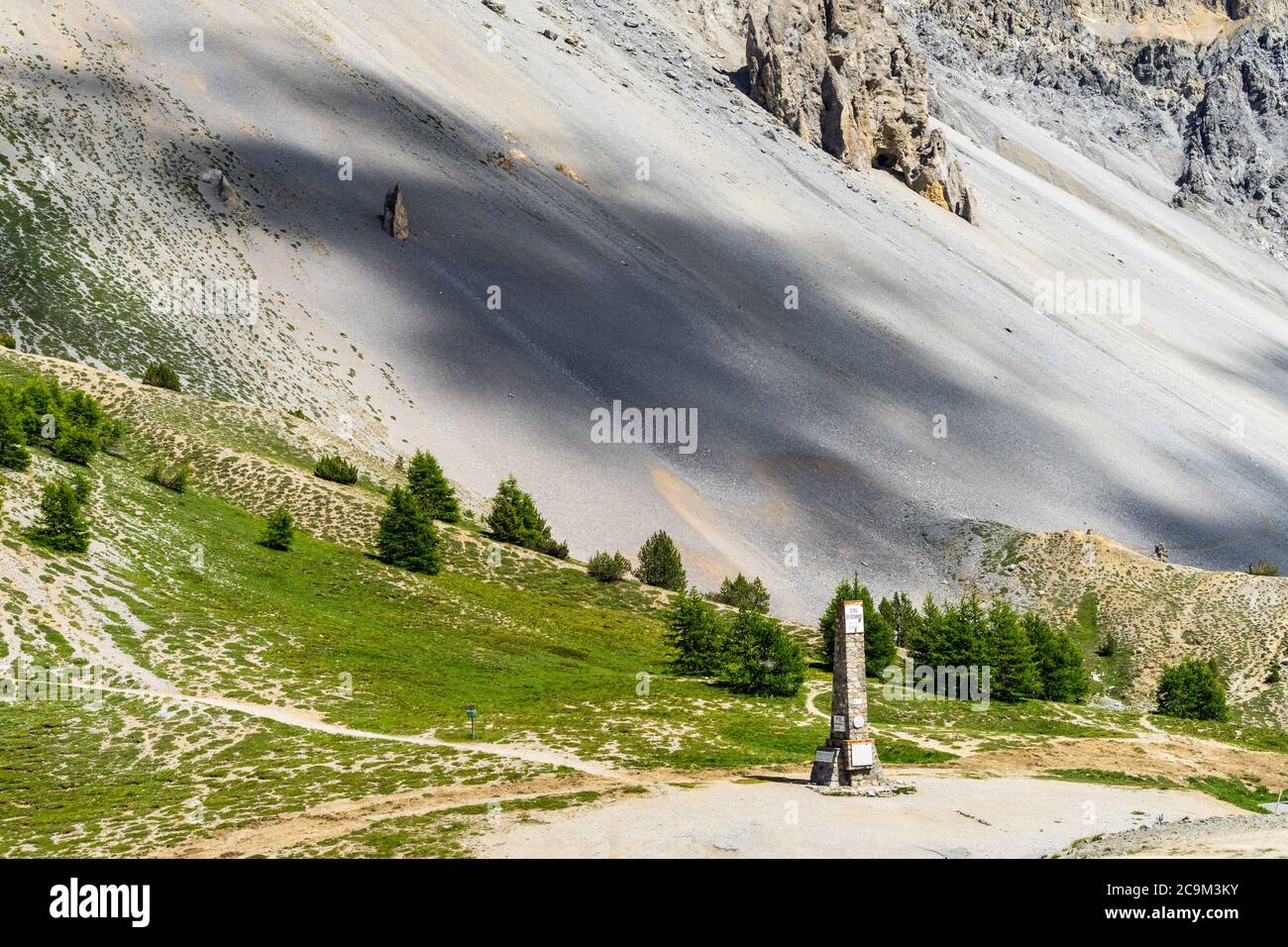 Memorial at the top of Col d'Izoard (2360) with the Casse Deserte in the background, Huates Alpes, France Stock Photo