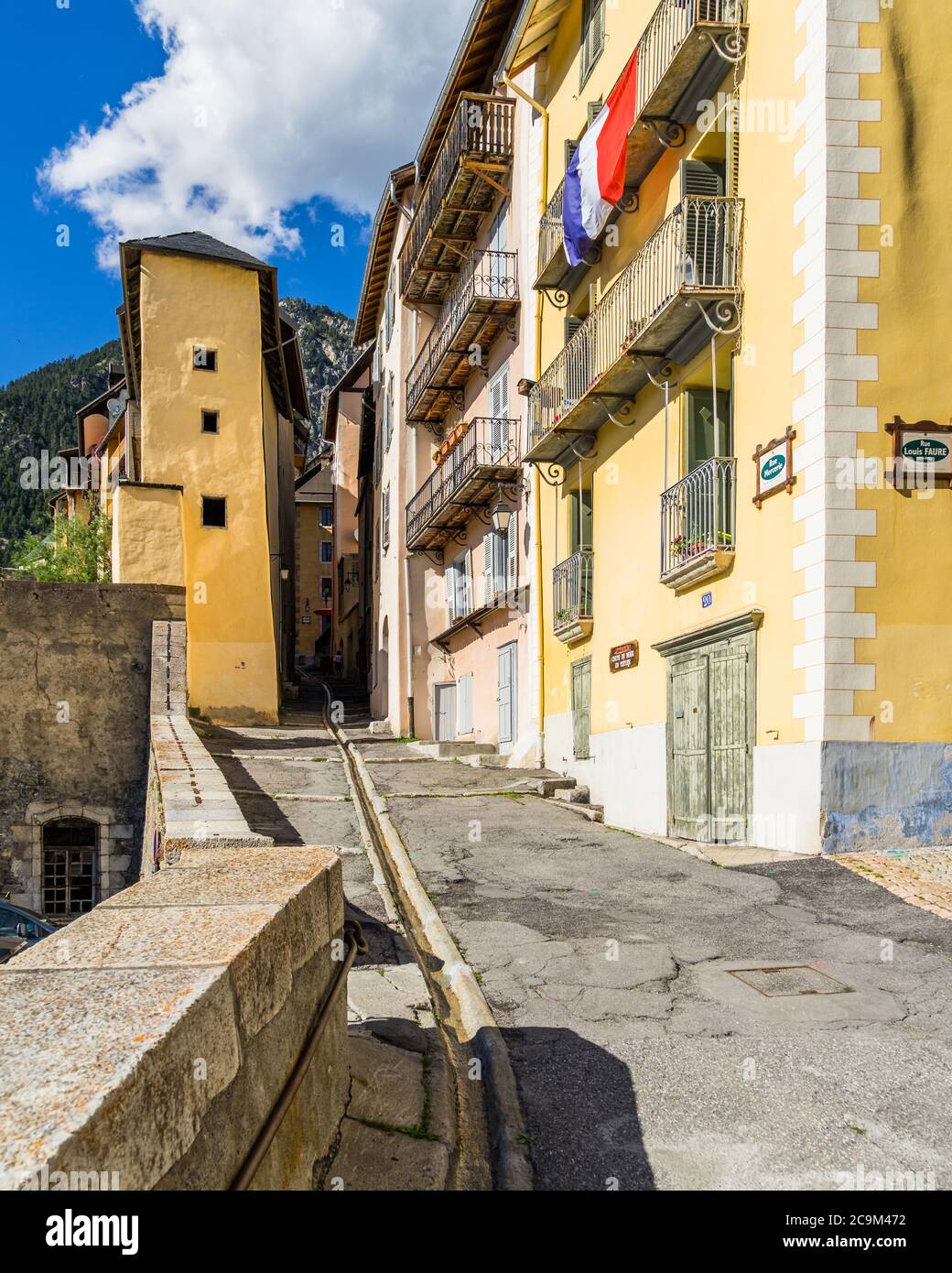 A steep and narrow alley with colorful traditional houses in Briancon old town, Hautes-Alpes, France Stock Photo