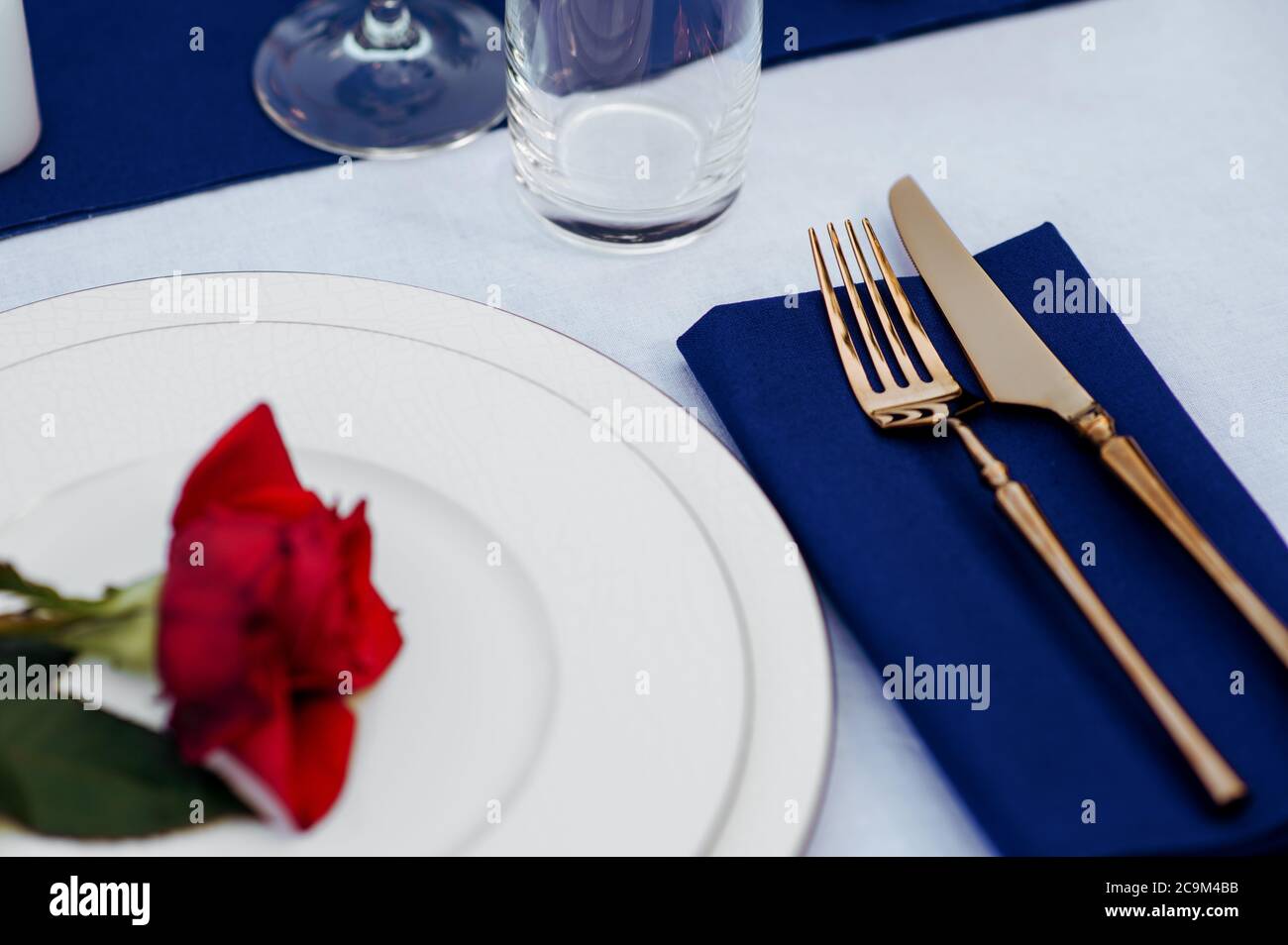 Table setting, silverware and red rose, top view Stock Photo