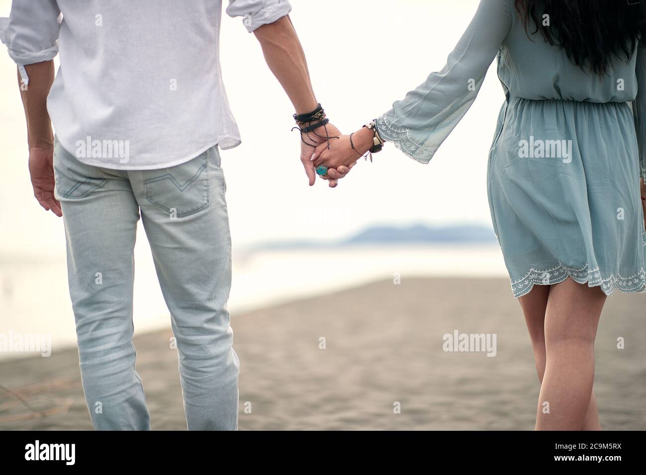 Couple holding hands.Romantic beautiful walk by the sea Stock Photo - Alamy