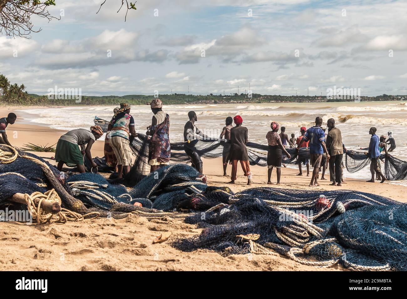 Fishing people on the beach cooperate with fish catch in Africa gold coast. Axim beach is located in Ghana West Africa. Photo 2018 October 31 Stock Photo