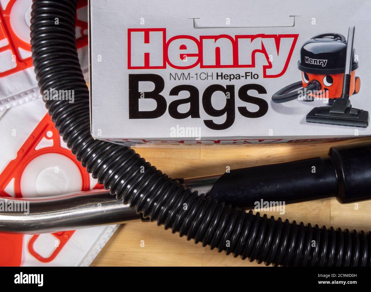Henry vacuum cleaner filter bags – overhead view of a retail box with two bags outside, together with a vacuum hose. Stock Photo