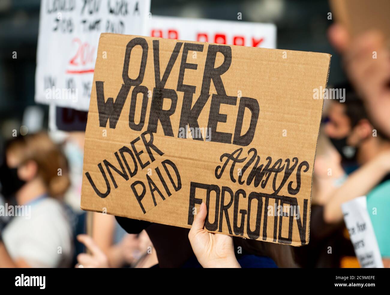 NHS (National Health Service) workers march in protest from St. Thomas' Hospital to Downing Street, London, to demand a pay rise from the government. Stock Photo