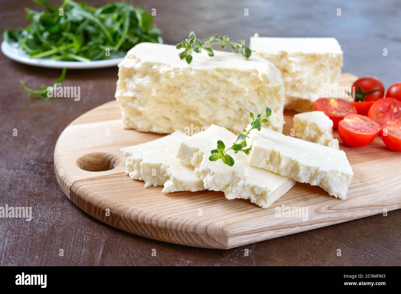 Delicious healthy sheep or goat feta cheese. Chunks of cheese on a wooden board. Stock Photo