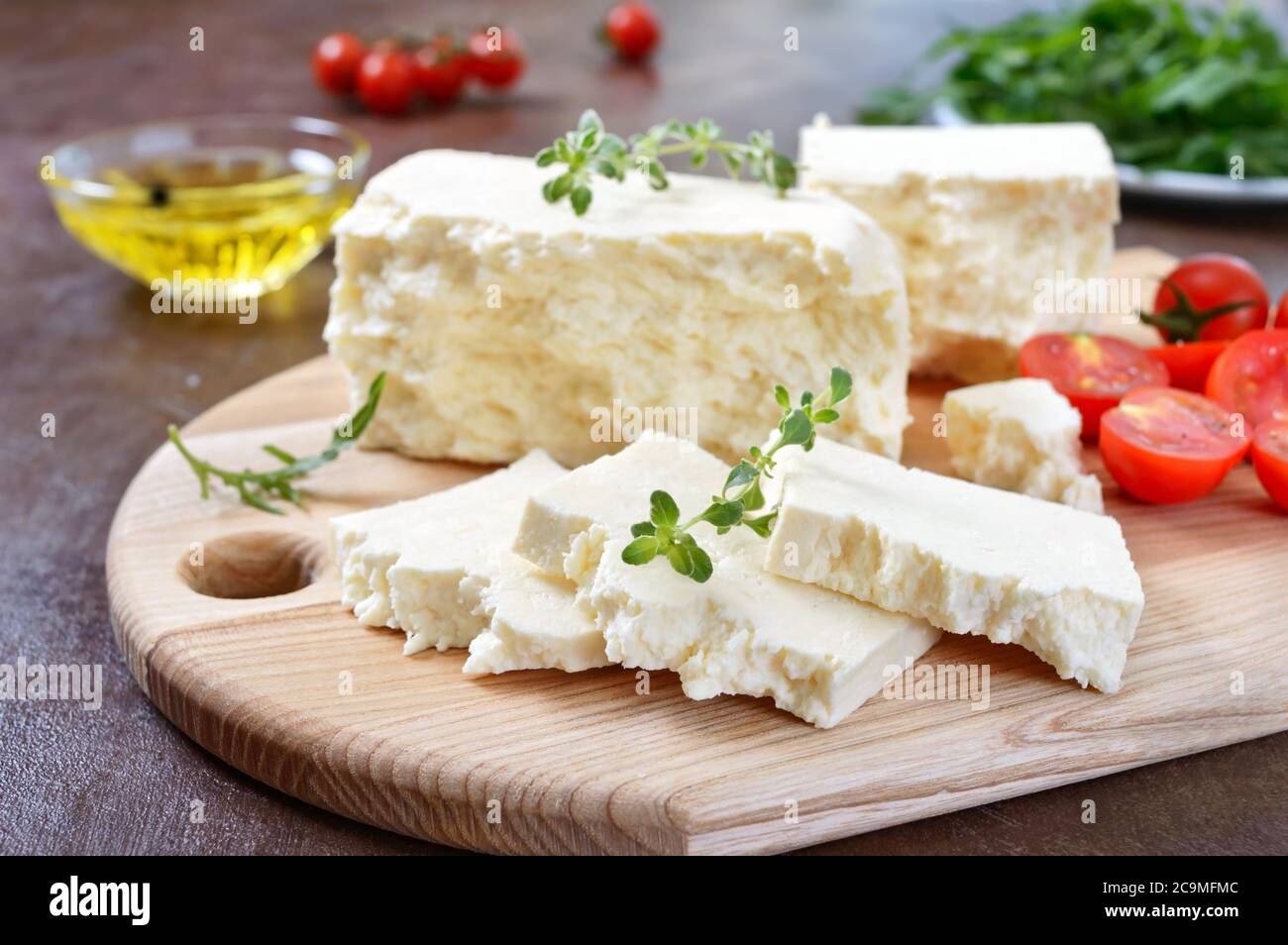 Delicious healthy sheep or goat feta cheese. Chunks of cheese on a wooden board. Stock Photo