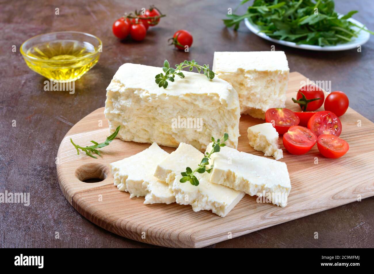 Delicious healthy sheep or goat feta cheese. Chunks of cheese on a wooden board. Stock Photo