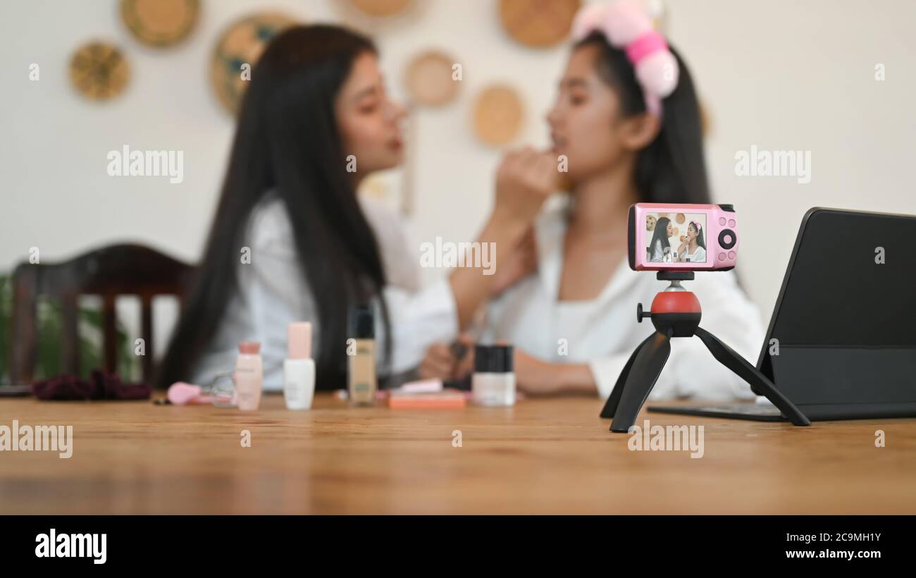 Selective focus camera and women are showing how to make up via online ...